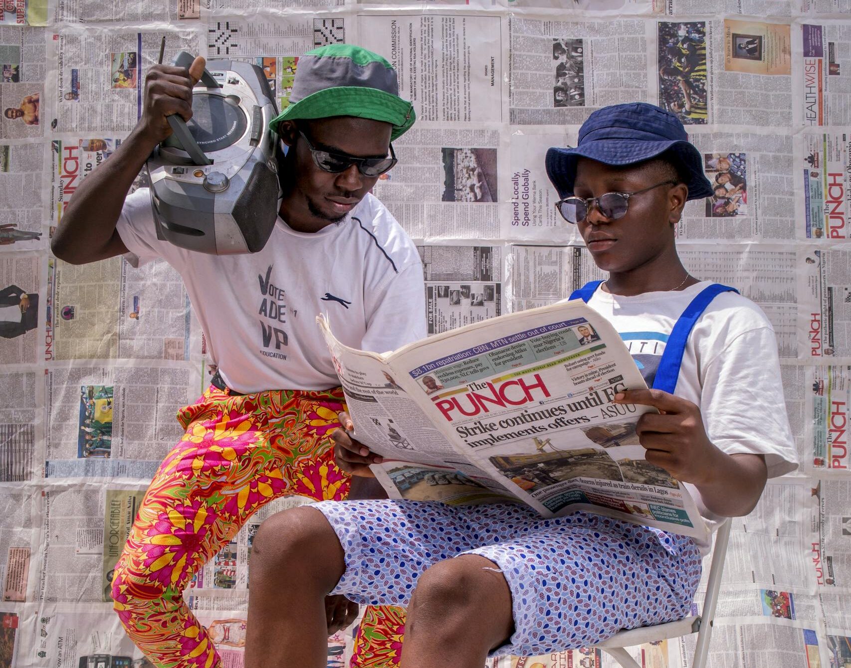Two stylish men in Nigeria enjoying a sunny day with vintage style and flair.